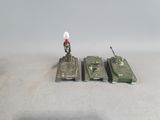 three toy tanks sitting next to each other on a table