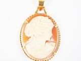 Un pendentif plaqué or représente le profil d'une femme.