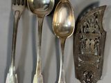 five silver spoons and two silver spoons on a table