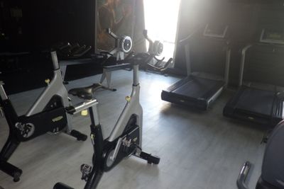une photo d'une salle de sport avec des vélos d'appartement