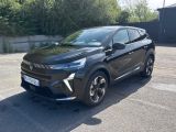 une voiture noire garée sur un parking près d'un mur