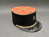un chapeau noir orné d'un emblème rouge et or