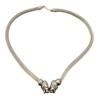 une image représentant un collier orné de deux perles en argent sur fond blanc