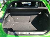 the back of a green car with its trunk open in a parking lot