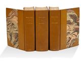 trois livres sont empilés sur une surface blanche