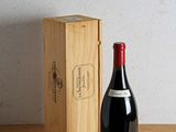 a bottle of wine next to a wooden box on a table
