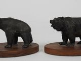 pair of black bears on wooden bases on a white background