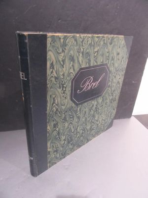 un livre posé sur une table devant un mur noir