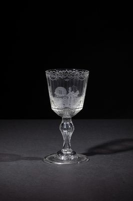 an empty wine glass sitting on top of a table next to a black background