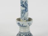 a small blue and white vase with a bird on it