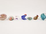 a group of glass birds sitting on top of a white surface