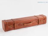 une valise en cuir marron posée sur une surface blanche, sur fond blanc
