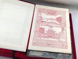 un livre ouvert posé dans une boîte rouge sur une surface blanche