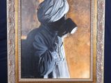 painting of a man with a turban on a easel in front of a blue background
