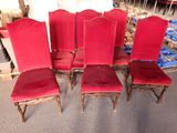 quatre chaises rouges sont alignées en rangée sur le sol