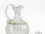 a clear glass pitcher with a gold trim and a spoon