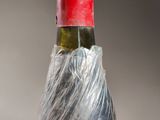 a bottle of wine wrapped in plastic on a table