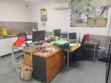 an image of an office with a lot of clutter on the desk