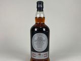 une bouteille de whisky posée sur une surface blanche