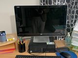 un bureau sur lequel se trouvent un écran, un clavier, une souris et d'autres éléments
