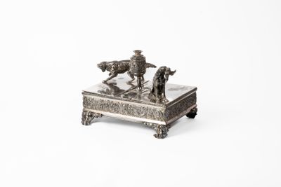 a silver figurine of a man on a horse and a dog