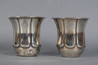 two silver vases sitting next to each other on a table