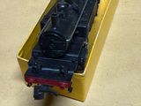 un petit train posé dans une boîte jaune sur une table