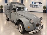 un petit camion gris garé dans une grande pièce