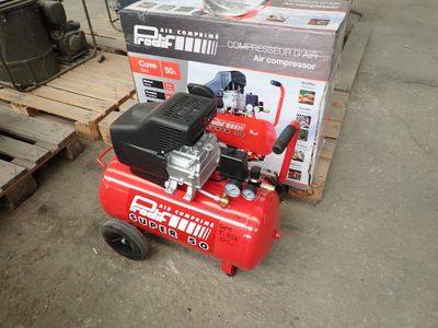 a red air compressor sitting on a pallet next to a stack of boxes