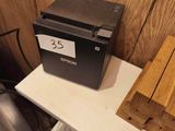 a wooden box on a white table next to a black box on a white table