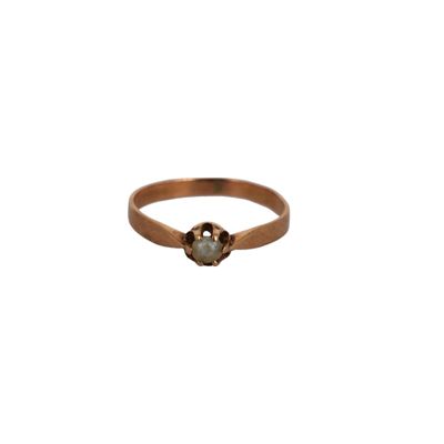gros plan d'une bague en or avec une pierre verte