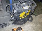 un sac avec un tuyau et une paire de chaussures à côté