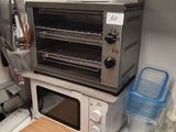 a toaster oven sitting on top of a counter next to a cutting board