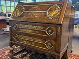 un vieux bureau en bois orné de sculptures élaborées, dans une pièce