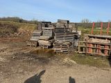 shadows of two people standing in front of a pile of pallets
