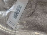 a label on the back of a sweater that is wrapped in plastic