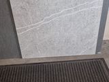 un tapis noir posé par terre près d'une porte