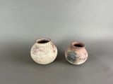deux petits vases posés côte à côte sur une surface grise