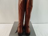 brown leather boots on a gray box on a white surface