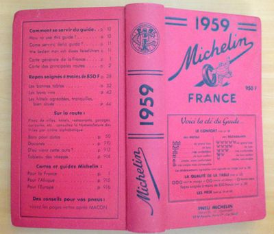 un vieux livre à la couverture rose posé sur une table en bois