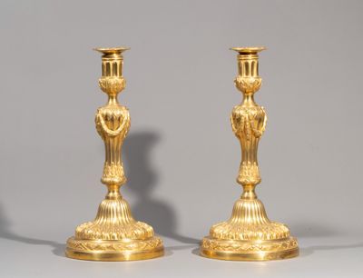 pair of antique brass candlesticks on a white background