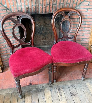 deux fauteuils rouges placés l'un à côté de l'autre devant une cheminée