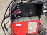 an image of a red and black welding machine in a garage