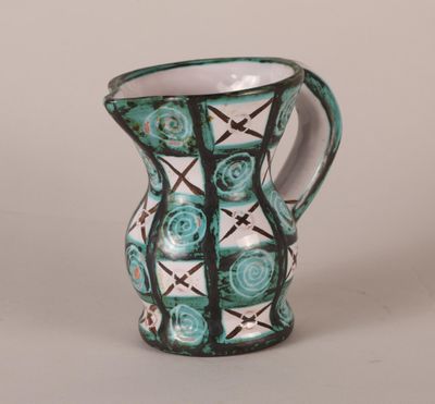 a green and white vase with a black and white design on it