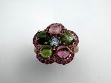 a close up of a pink and green ring on a white surface