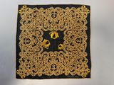 a close up of a black and gold scarf with a horse on it