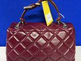 a red quilted purse with a tag on it