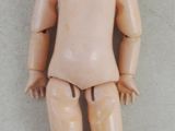 a small doll that is sitting on a white surface