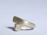 gros plan d'une bague en argent sur une surface blanche