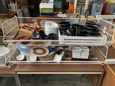de nombreux plats et bols disposés dans un panier en fil de fer posé sur une table